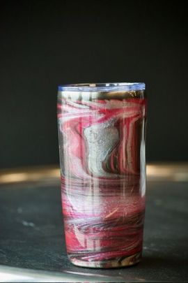 A custom marbled tumbler with red, silver, and charcoal swirls.